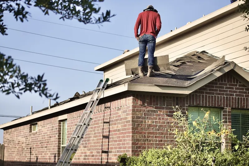 Professional roofer working on a residential roof in New Birmingham Manor